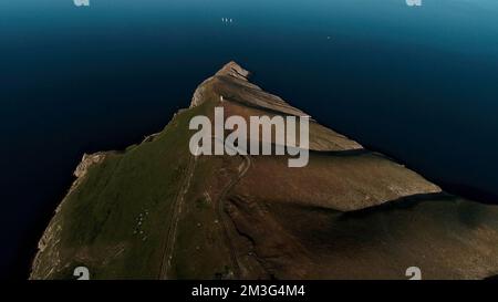 Aerial view of a natural cape and a dark blue sea. Shot. Picturesque background with a green mountain and sea water Stock Photo