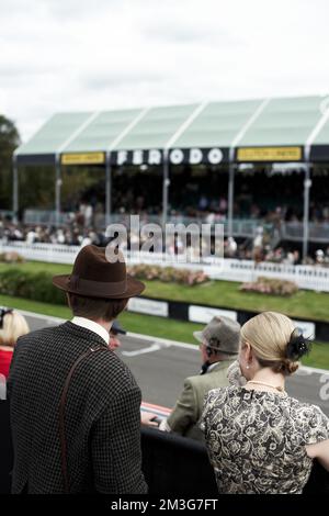 Couple watching the race on the grandstand at the Goodwood Revival. Stock Photo