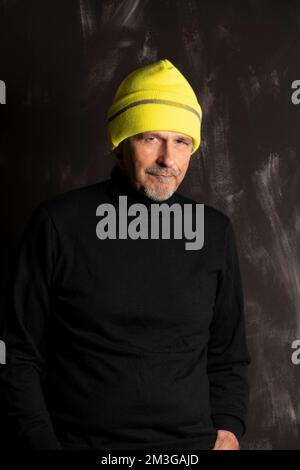 Older man with yellow winter cap smiles Stock Photo