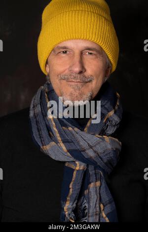 Older man with yellow winter cap smiles Stock Photo
