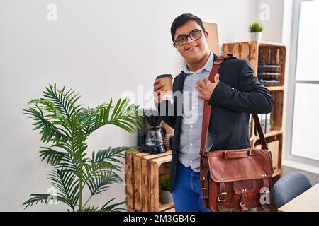 Down syndrome man business worker drinking coffee at office Stock Photo