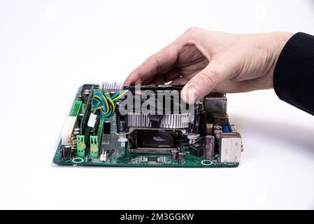 Engineer repairman holding hands in black gloves chip processor, CPU to insert into the socket of the computer motherboard. The concept of technology Stock Photo