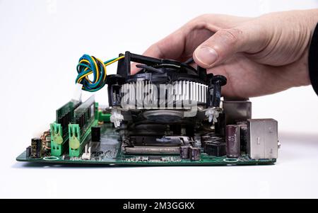 Engineer repairman holding hands in black gloves chip processor, CPU to insert into the socket of the computer motherboard. The concept of technology Stock Photo