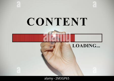 Woman hand with glitter nails showing the Loading Bar with the text “Content” Stock Photo