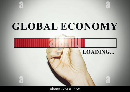 Business Woman hand with glitter nails showing the Loading Bar with the text “Global Economy” Stock Photo