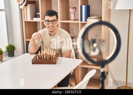 Young arab man doing chess tutorial smiling happy pointing with hand and finger Stock Photo