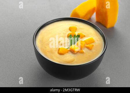 Vegan curried pumpkin lentil soup puree in a bowl. Space for text. Pescatarian Eating, Flexitarian Eating, Reducetarian Eating. Stock Photo