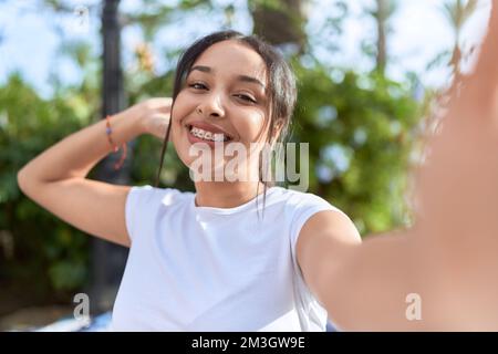 Young arab woman smiling confident making selfie by camera at street Stock Photo