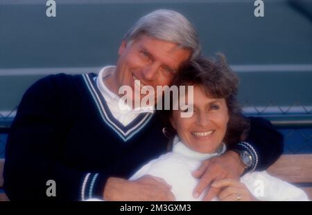 Older couple embracing while posing to look at the camera Stock Photo