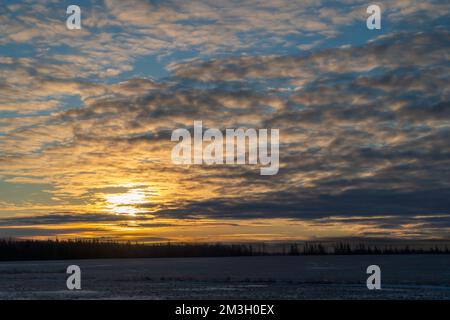 Sunset over winter farm fields in rural Canada. Stock Photo