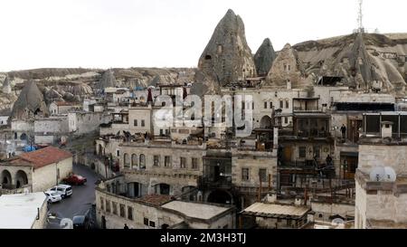 Ancient stone dwellings carved from tuff in Cappadocia, Turkey, aerial. Action. Aerial view of beautiful city with rock formations Stock Photo