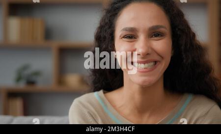 Close up female 30s adult pensive lady dreaming thoughtful Hispanic Caucasian woman thinking looking away turn head to camera smiling toothy dental Stock Photo