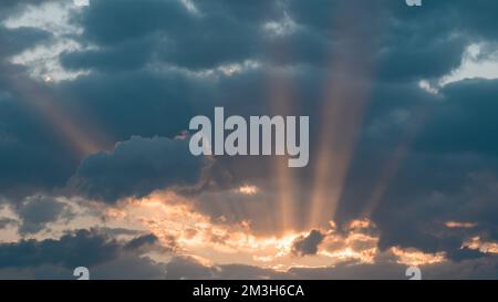 Dramatic sunset with dark clouds and glimpses of light, sun rays ...