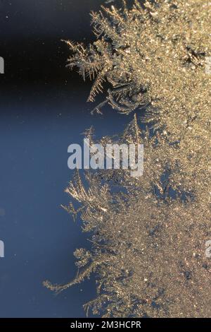 Macro image of ice crystals from frost formed on a window with dark blue background Stock Photo