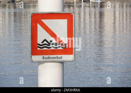 Red square signpost saying in German bathing prohibited attached on a metal pole. Stock Photo