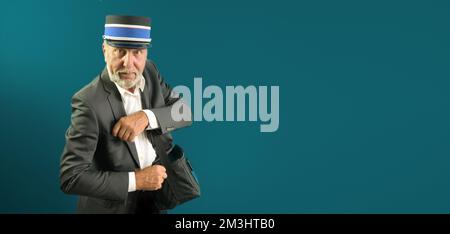 Senior adult conductor serves the passenger with a smile. Banner. On a green background. Stock Photo