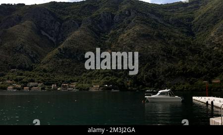 Breathtaking natural background with a moored small yacht near the pier. Creative. Mountains and large turquoise lake Stock Photo