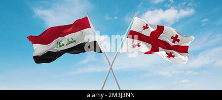 two crossed flags Iraq and Georgia waving in wind at cloudy sky ...