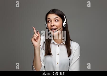 friendly smiling woman with headset is consulting clients online. Stock Photo