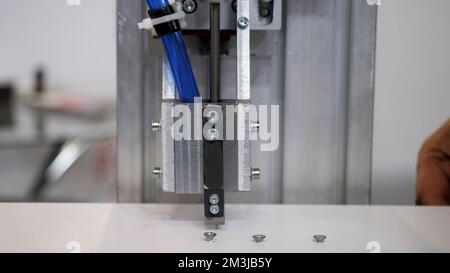 Industrial robot using automatic screwdriver on wooden product. Media. industrial machine at work at the construction site or factory Stock Photo