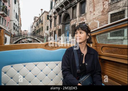 fashionable woman enjoying boat taxi ride in Venice Stock Photo