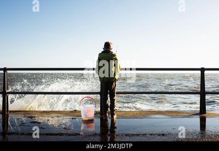 young boy fishing for crabs on a beautiful winter day Stock Photo