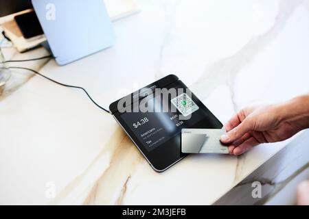 Hand of male customer paying with credit card on modern POS system Stock Photo