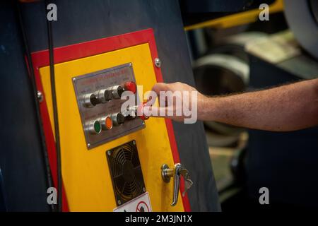 Professional worker pressing buttons on machine control board Stock Photo