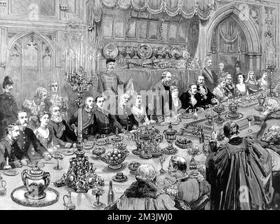 Banquet scene at London's Guildhall. An annual banquet is traditionally held to celebrate the mayor's installation in November each year. The Lord Mayor can be seen seated on a lavishly carved chair, six places from the right of the picture. To his right sits his predecessor. Lord Salisbury can be seen standing to speak.     Date: 9th November 1887 Stock Photo