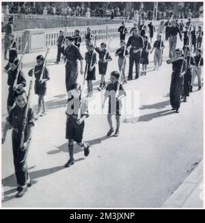 Spanish children of General Franco's 'Arrows' (Young Fascists), marching with dummy rifles, Burgos. Stock Photo
