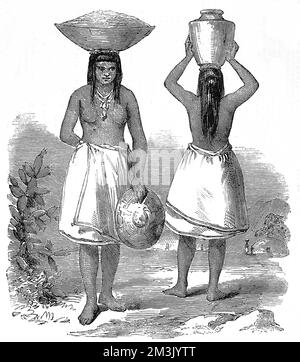 Two native American Indian women of the Pimo tribe carrying baskets and water vessels on their heads, wearing full wrap around skirts and heavy jewellery. Stock Photo