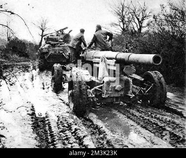 Photograph showing a French 155-mm gun, used by the German army to shell Allied shipping, captured by British troops and being towed by a Sherman tank, Italy, 1944.  The snow and mud of winter warfare in Italy is well captured in this image.     Date: 1944 Stock Photo