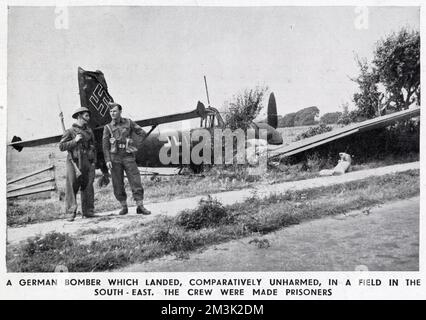 A crashed German Junkers Ju-87 dive-bomber, also known as a 'Stuka', somewhere in South East England during the summer of 1940. Two British soldiers are seen guarding the crashed airplane. Stock Photo