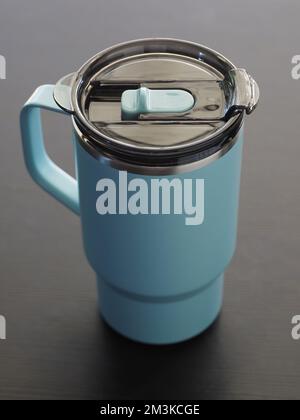 Blue aluminum thermos mug on wooden table. Stock Photo