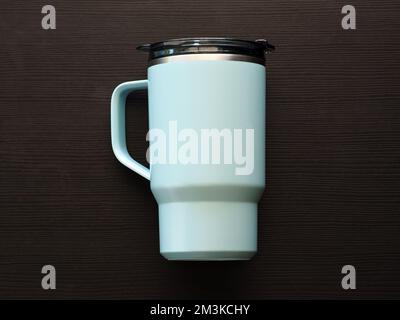Blue aluminum thermos mug on wooden table. Stock Photo