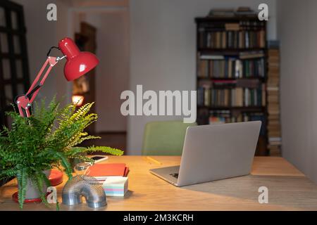 Home office setup for remote working, Cozy workplace with laptop, desk lamp and office supplies  Stock Photo