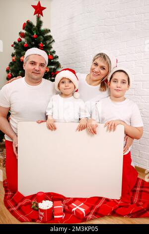 Family with white board, pointing or presenting empty white placard. Stock Photo