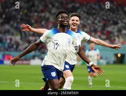 File photo dated 21-11-2022 of England's Bukayo Saka (left) celebrates scoring their side's second goal of the game during the FIFA World Cup Group B match at the Khalifa International Stadium, Doha. England’s quest for glory in Qatar got off to a dream start as Bukayo Saka’s brace helped Gareth Southgate’s men beat Iran 6-2 in their World Cup opener. Issue date: Friday December 16, 2022. Stock Photo