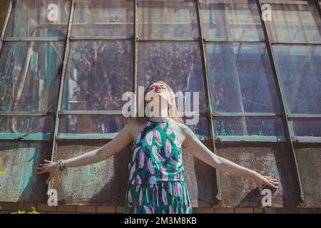 Young woman with closed eyes posing against tall windows scenic photography Stock Photo