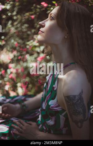 Close up young woman enjoying time among flowering shrubs portrait picture Stock Photo