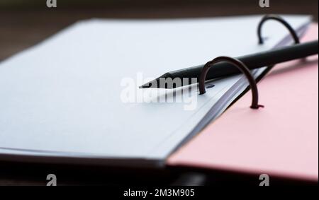 Blank notepad with pink and white pages with black pencil Stock Photo