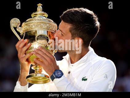 File photo dated 10-07-2022. Novak Djokovic kisses the trophy after maintaining his stranglehold on Wimbledon. The Serbian beat a frustrated Nick Kyrgios 4-6 6-3 6-4 7-6 (3) to win a fourth consecutive title at the All England Club and a 21st grand slam crown. Another memorable centre court triumph was the highlight of a difficult year for Djokovic in which he was unable to compete at the Australian Open and the US Open due to his anti-vaccination stance. Issue date: Friday December 16, 2022. Stock Photo