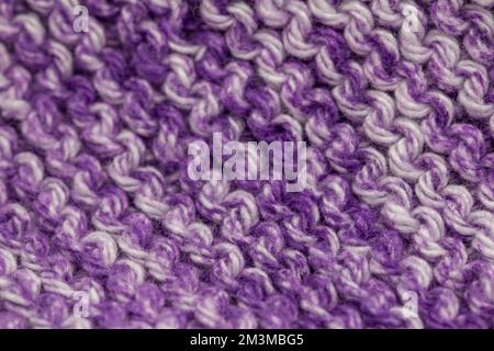 Defocused macro abstract texture background of a hand-knitted purple and white color cloth in a garter stitch pattern Stock Photo