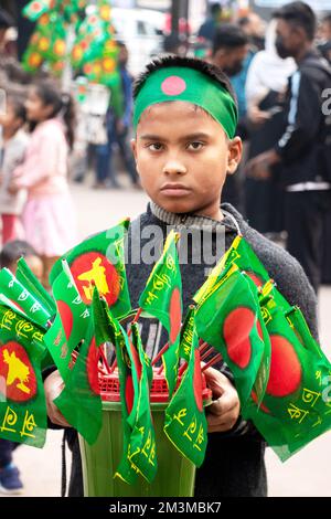 Narayanganj, Dhaka, Bangladesh. 16th Dec, 2022. A child displays Bangladesh National Flags to sell during the celebrations of the 52nd Victory Day, which marks the end of a bitter nine-month war of independence from Pakistan, in Narayanganj, Bangladesh. Bangladesh is celebrating the 52nd anniversary of its national victory, remembering the valiant freedom fighters who fought and made the ultimate sacrifice to free the country from the Pakistani forces. People from all walks of life gather at the Narayanganj Central Shaheed Minar in the morning to mark the most precious day of the Bangali pe Cr Stock Photo