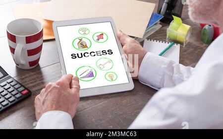 Success concept shown on a tablet held by a man Stock Photo