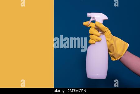 hand with a container of detergent. Blue-yellow background. Card Stock Photo