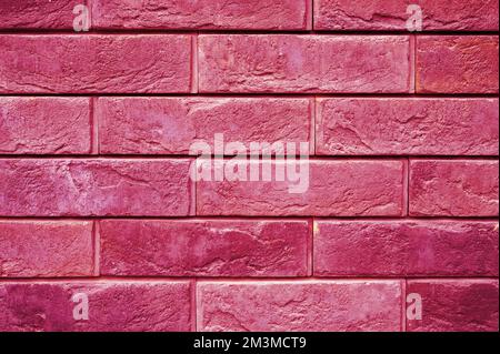 pattern of decorative pink slate stone wall surface as a background. toned in viva magenta, trend color of the year 2023 Stock Photo