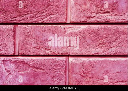pattern of decorative pink slate stone wall surface as a background. toned in viva magenta, trend color of the year 2023 Stock Photo