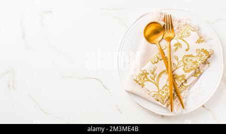 Festive place setting for Christmas or New Year in golden tone and copy space for your text Stock Photo
