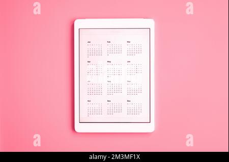 tablet computer with app of calendar for unspecified unknown date year without date. business or to do list goals. top view, flat lay. toned in viva m Stock Photo